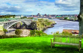 Wooden bench with the Reversing Falls bridge in Saint John city, Canada