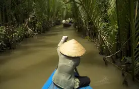 Vietnamese woman rowing a boat on the Mekong River in Vietnam