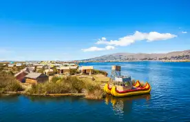 The floating islands on Titicaca Lake, featuring moored kayaks and wooden cabins