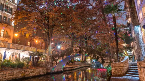 Stone bridge on river walk in San Antonio decorated with coloured lights for the holidays