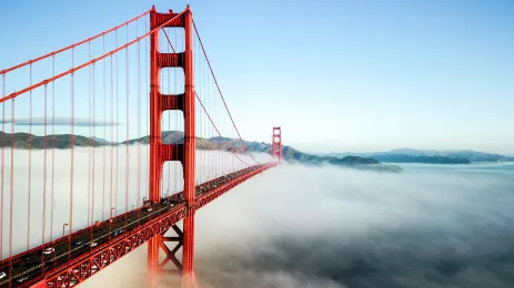 	Red bridge leading obscured from view by the fog on an otherwise clear day