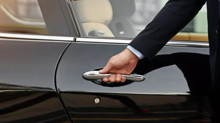 Close-up of concierge opening a private car door