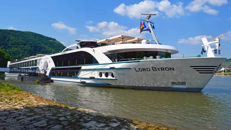 Side view of the MS Lord Byron docked near the coast