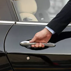 Close-up of concierge opening a private car door