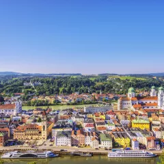 Elevated view of Passau, Germany, with sightseeing boats anchored in front of the town hall.