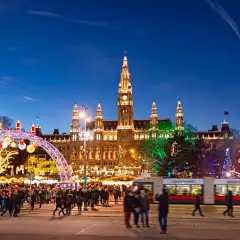 Christmas market with festive lights during the late evening in Rathausplatz square, Vienna, Austria