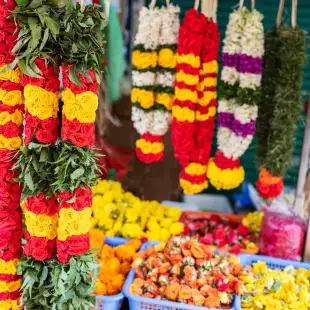 Colourful flower garlands at a market display for traditional ceremonies