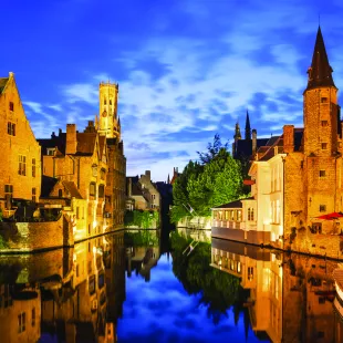 The Rozenhoedkaai canal and Belfort tower at twilight in Bruges