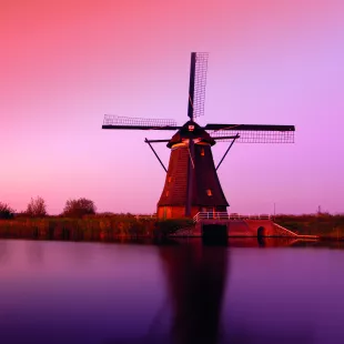 A pink sunset over the Lek River and Kinderdijk windmill monuments, South Holland, Netherlands