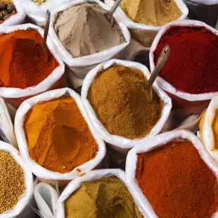 Rows of bags filled with to the brim with powdered spices at Indian market