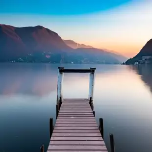 Sunset at Lake Lugano from wooden jetty in Switzerland