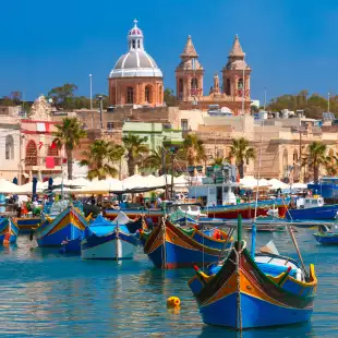 Traditional colourful eyed boats Luzzu at harbour in Marsaxlokk, Malta