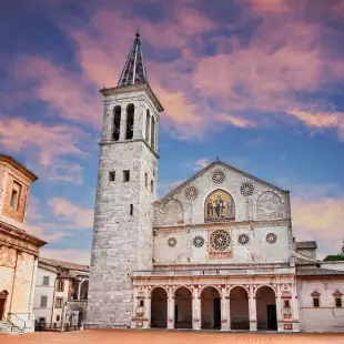 The medieval cathedral of Santa Maria Assunta with a colourful evening sky in Umbria, Italy.