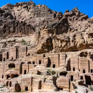 Desert canyon walls lined with carved stone tombs entrances, Jordan