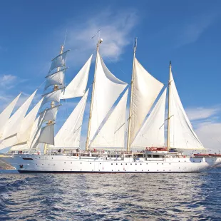 Exterior of the Star Clipper tall ship sailing under a blue sky