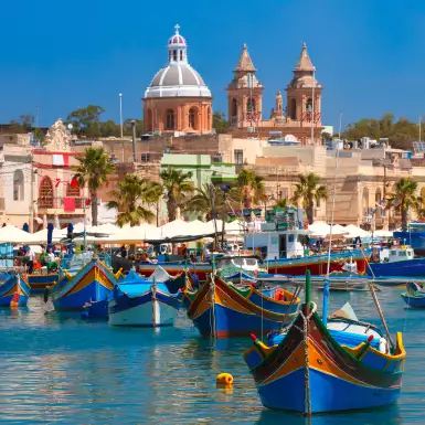 Traditional colourful eyed boats Luzzu at harbour in Marsaxlokk, Malta