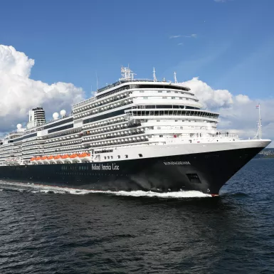 Exterior of the MS Koningsdam in motion along the sea, a Holland America Line ship