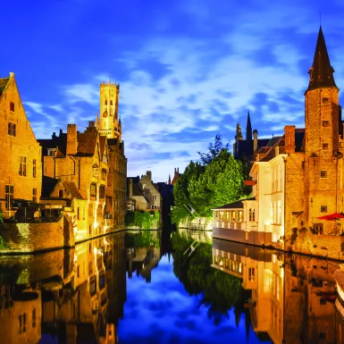 The Rozenhoedkaai canal and Belfort tower at twilight in Bruges