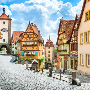 Historical half-timbered houses and cobbled streets of Rothenburg on a sunny day with blue sky and clouds in Franconia, Bavaria, Germany.