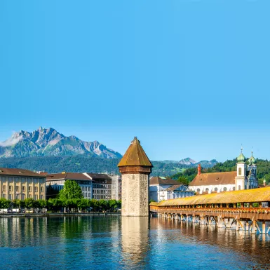 Scenic panoramic view of Lucerne, Switzerland with Chapel bridge or Kapellbrucke and Pilatus mount with clear blue sky during summer