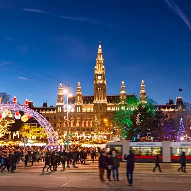Christmas market with festive lights during the late evening in Rathausplatz square, Vienna, Austria