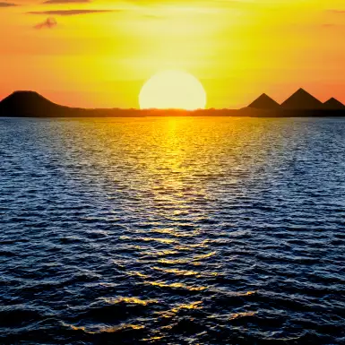 Beautiful sunset light reflecting in the sea and the Egyptian Pyramids