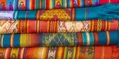 A pile of colorful Andes textiles on the sunday art and craft market of Otavalo in Ecuador, north of Quito.