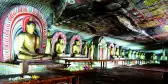 Interior of the Dambulla Golden Cave Temple with rows of golden Buddha statues and painted ceilings, Sri Lanka, South Asia.