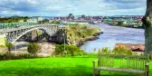 Wooden bench with the Reversing Falls bridge in Saint John city, Canada