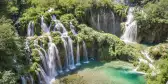 Croatia waterfalls with tourists overlooking the beautiful view from a nearby hanging bridge