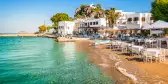 Bright and colourful view of Skala town with small beach in Patmos, Greece