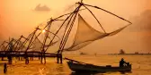 A sunset over fishing nets and boat in Cochin (Kochi), India