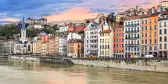 Saône river along Lyon townhouses under a sunset sky, France