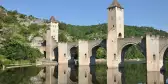 Pont Valentré Bridge reflecting it's image in the Lot River, Cahors, France