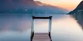 Sunset at Lake Lugano from wooden jetty in Switzerland