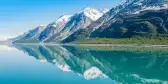 Snowy mountains being reflected on clear waters in Glacier Bay National Park, Alaska