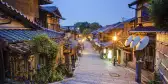 Old street of Kyoto in a Japanese town, lit by street lights under an early evening sky