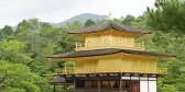 Golden ornate Japanese temple by the waterside and surrounded by green forests, Japan