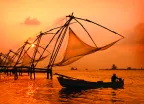 A sunset over fishing nets and boat in Cochin (Kochi), India