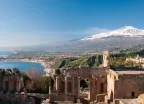 Taormina theatre columns with snowy Mount Etna in the distance in Taormina, Italy 