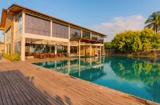 Sunrise over Regenta Arie Lagoon's pool and surrounding greenery 