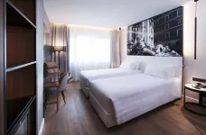 Standard twin bedroom featuring a contemporary aesthetic at hotel Radisson Blu in Rome, Italy.
