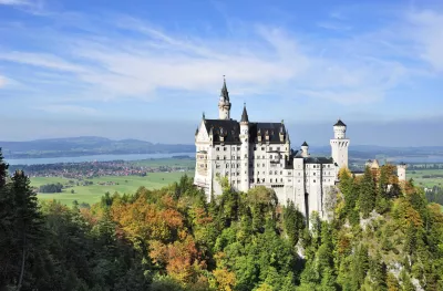Aerial of Neuschwanstein castle surrounded by vegetation in Bavaria, Germany
