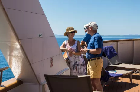 Mature friends talking and smiling on board the Il Mare yacht