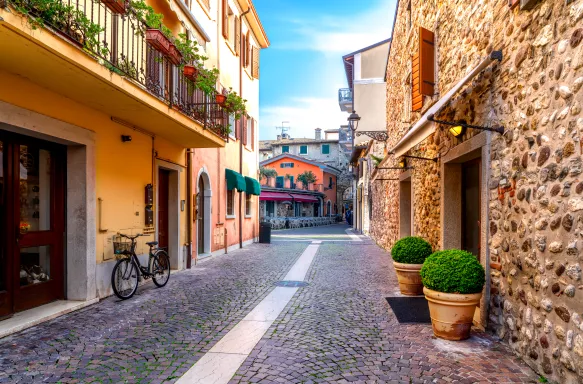 Narrow street in the old town of Bardolino with pebblestone pavements on a sunny day 