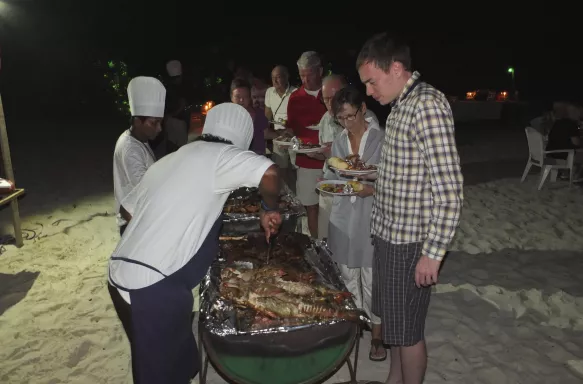 Group of people at  BBQ serving food at night