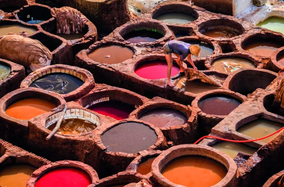 Man working in leather tanneries in medina Fez, Morocco