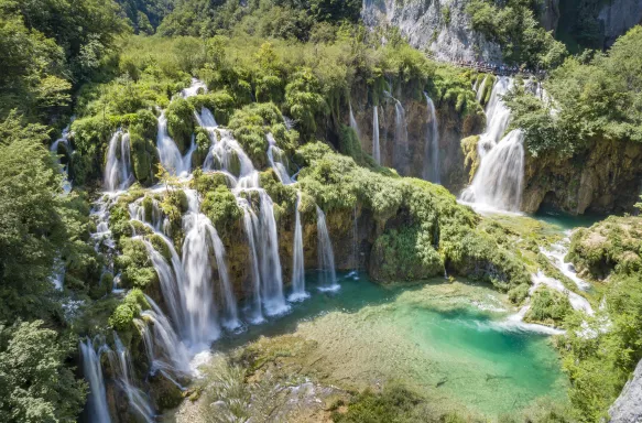 Croatia waterfalls with tourists overlooking the beautiful view from a nearby hanging bridge