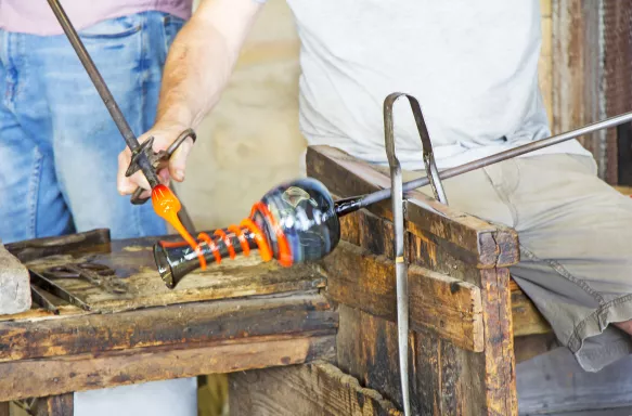 Glass worker sculpting in glass factory in Murano, Venice, Italy