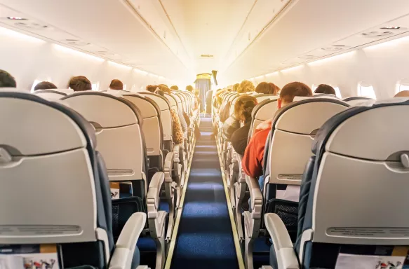 Commercial aircraft cabin with rows of seats down the aisle. morning light in the salon of the airliner.